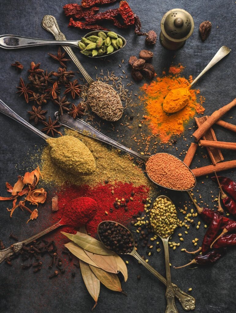alt="Image of various spices in spoons on a table"