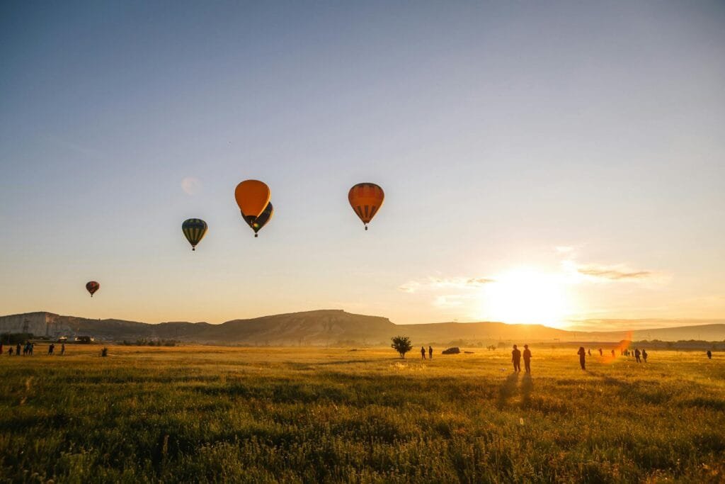 alt="Image of Hot air Balloons flying in sunset"