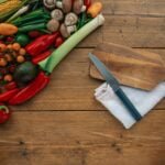 alt="Image of Knife on a cutting board next to veggies"