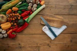 alt="Image of Knife on a cutting board next to veggies"