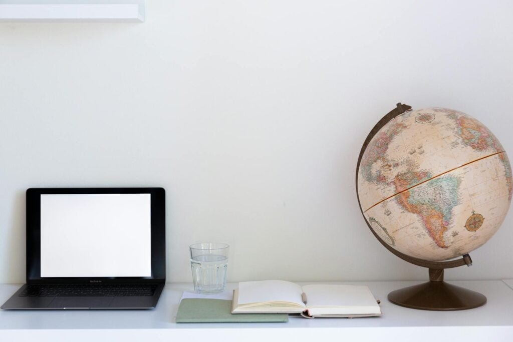 alt="Picture of Laptop next to a globe"