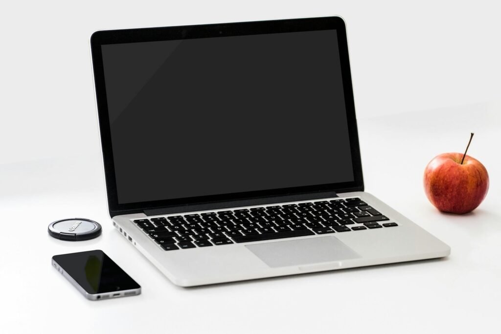alt="Picture of Laptop next to an apple and phone"