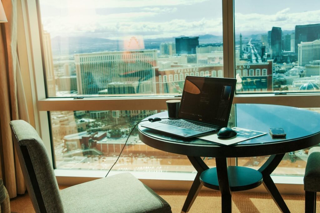 alt="Picture of Laptop on a table with sunset through the window"