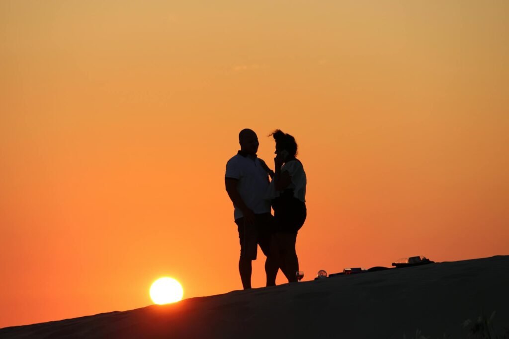 alt="Picture of Man and woman on a mountain in sunset"