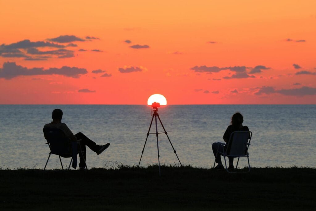 alt="Picture of Man and woman sitting in sunset"