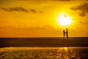 alt="Picture of Man and woman standing in sunset"