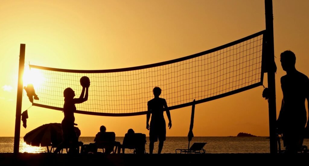alt="Picture of People playing beach volleyball sunset"