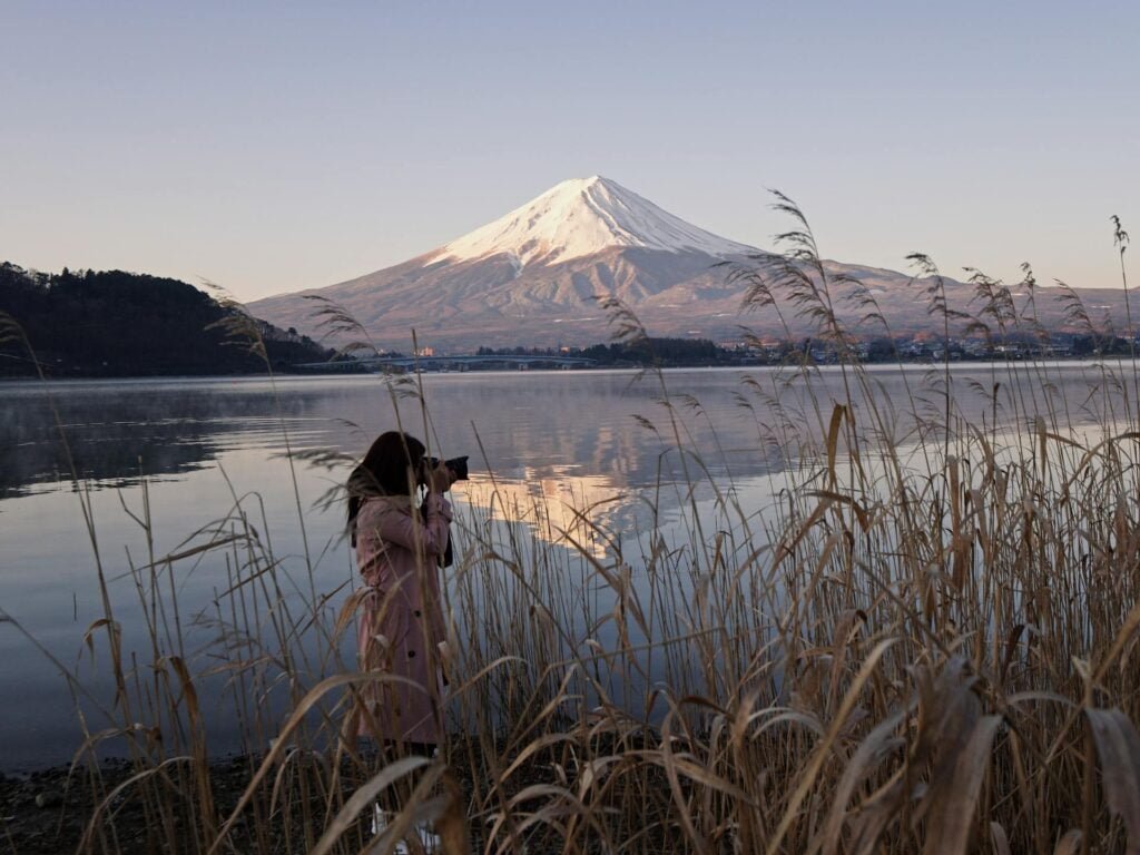 alt="Picture of Woman taking photo near mountain"
