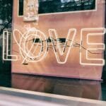 alt=”Image of Neon sign with love written on it”