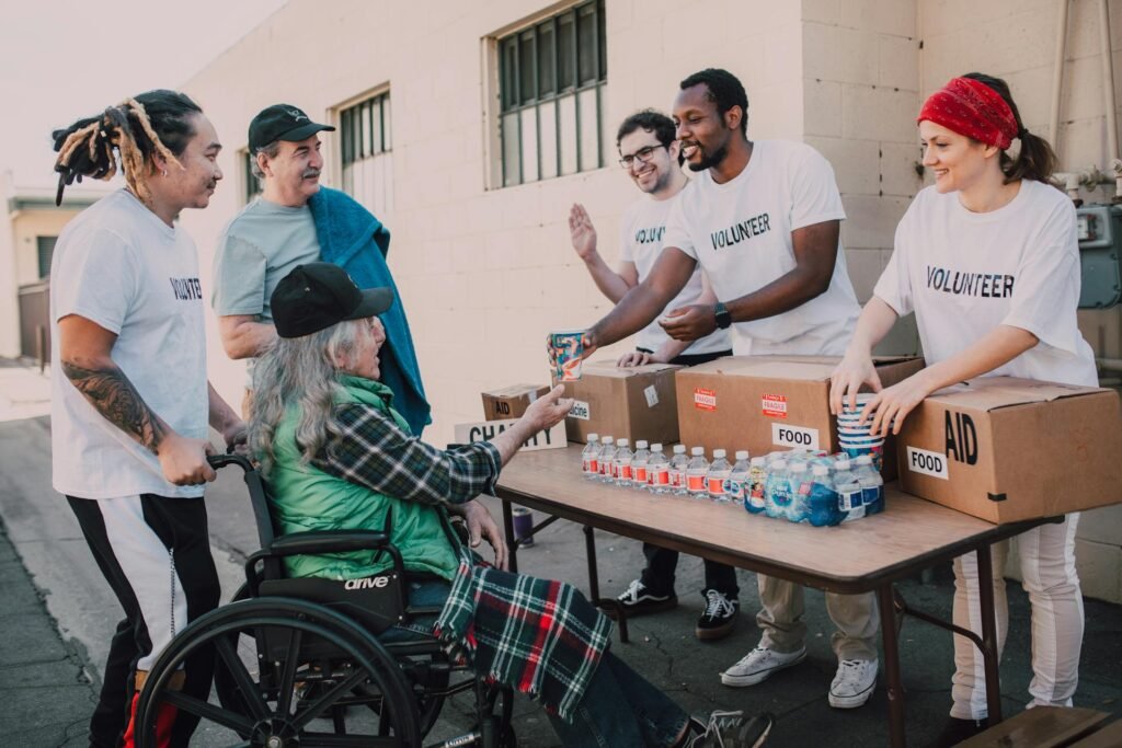 alt=”Image of Volunteers handing out drinks”