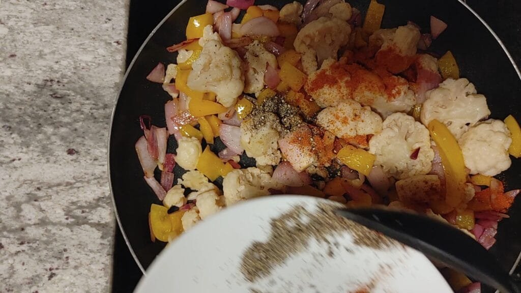 alt="Adding Black Pepper to pan"