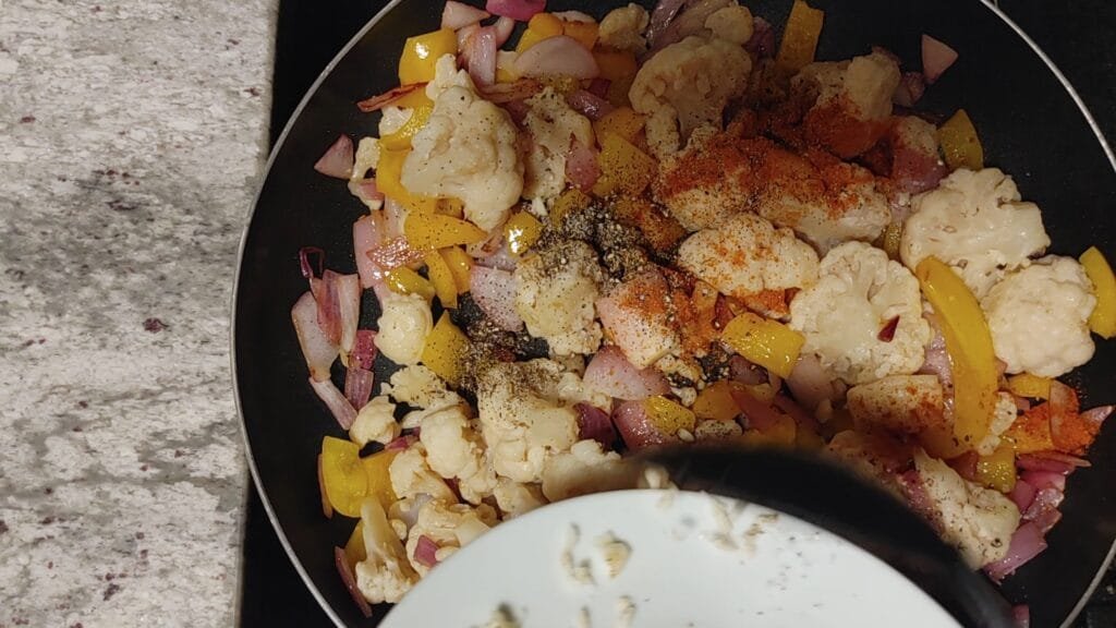 alt="Adding Garlic to pan"