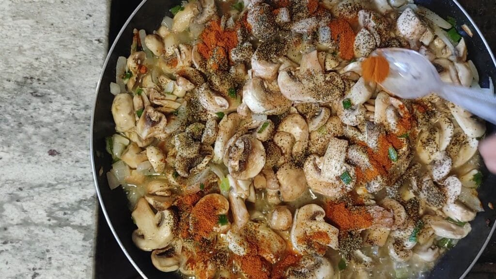 alt="Adding red pepper to pan"