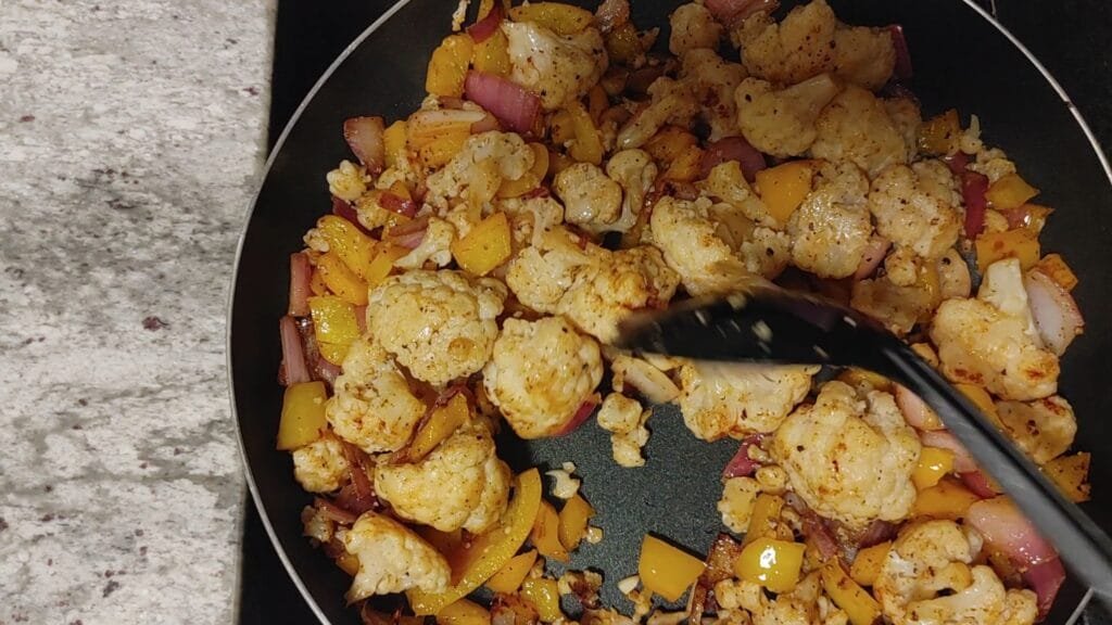 alt="Stirring Cauliflower in pan"