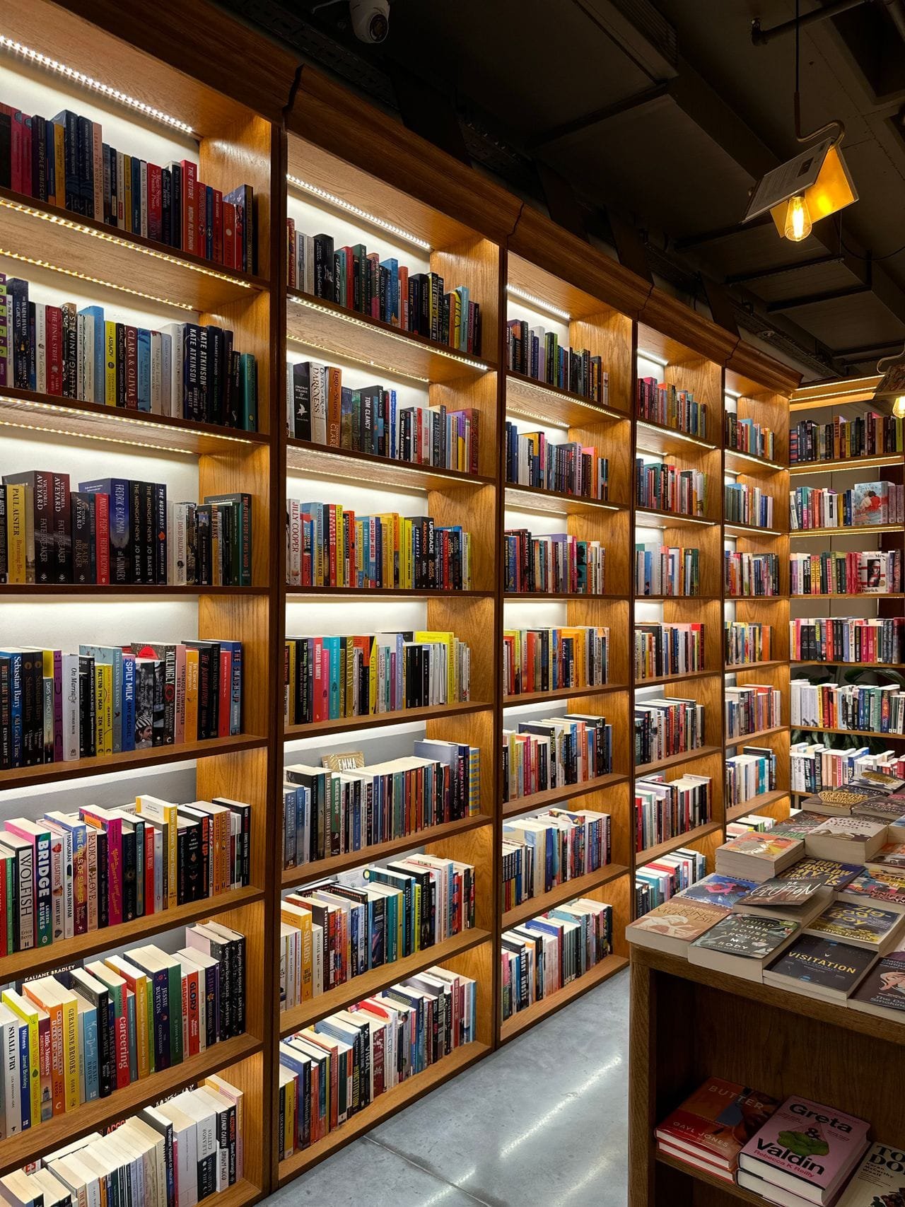 alt="Book shelves and tables filled with books"