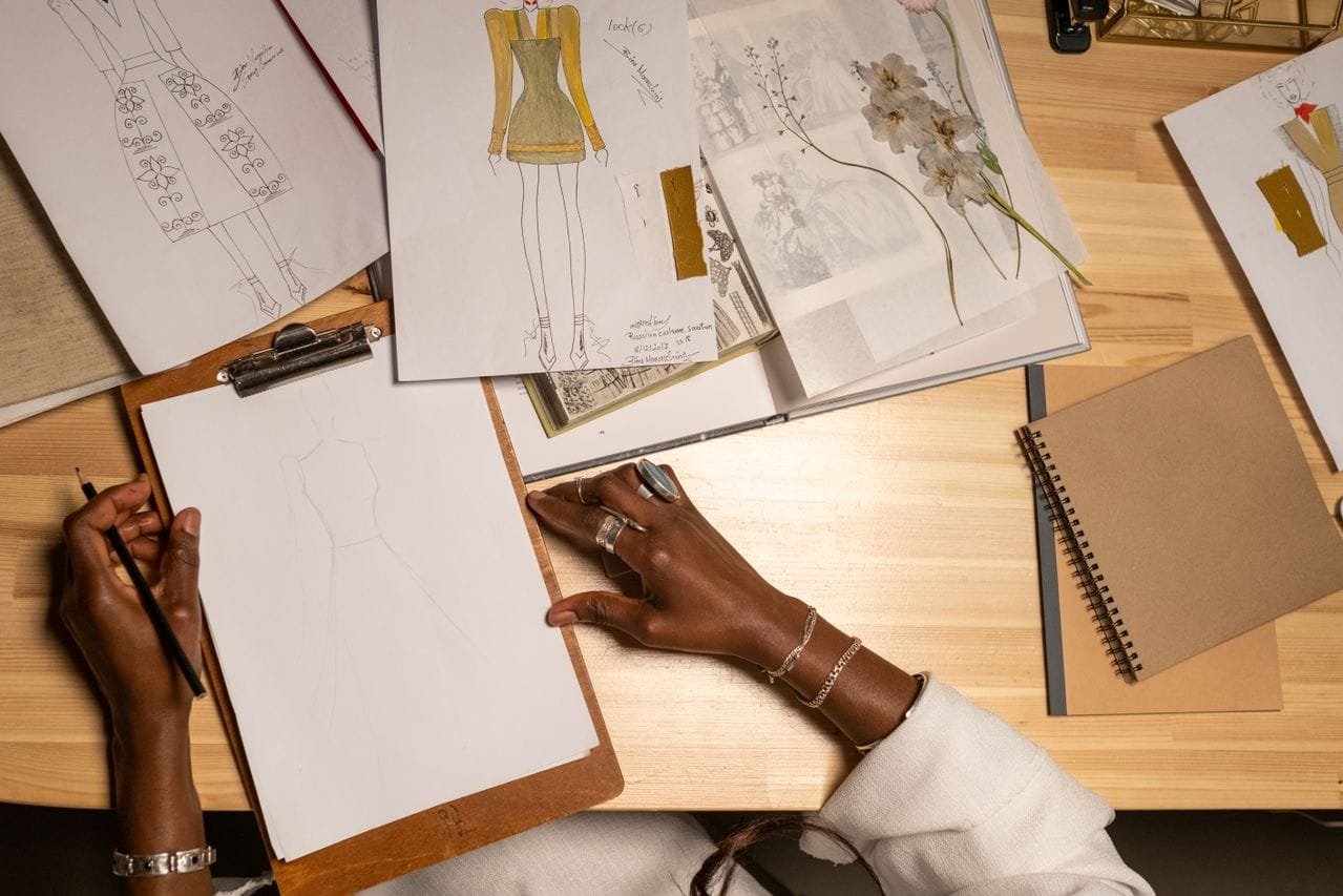 alt="Hand drawing fashion designs"