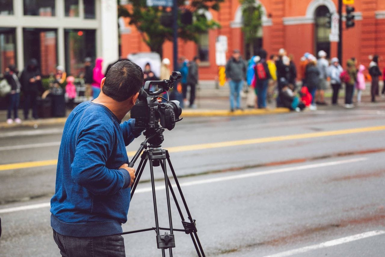 alt="Person filming group of people"